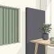 Rustige kantoorhoek met akoestisch wandpaneel en scheidingswand in salie groen en warmwit, potplant op minimalistisch bureau.