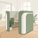 Akoestische privacypod met minimalistisch bureau, saliegroen bekleed en omringd door licht eikenhout in een open kantoorruimte.