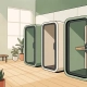 Drie akoestische telefoonbooths in een modern Nederlands kantoor met lichthouten vloer en salie groene tinten.