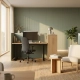Modern open-plan kantoor met zit-stabureau, loungehoek en vloer-tot-plafond ramen in salie groen en eikenhout tinten.